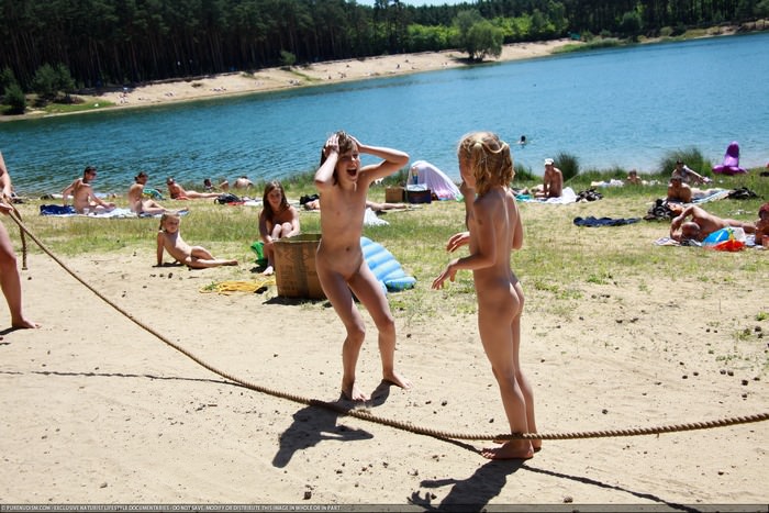 On a sunny summer day naturists take a rest with their families on the lake photo [家族のヌーディズム]